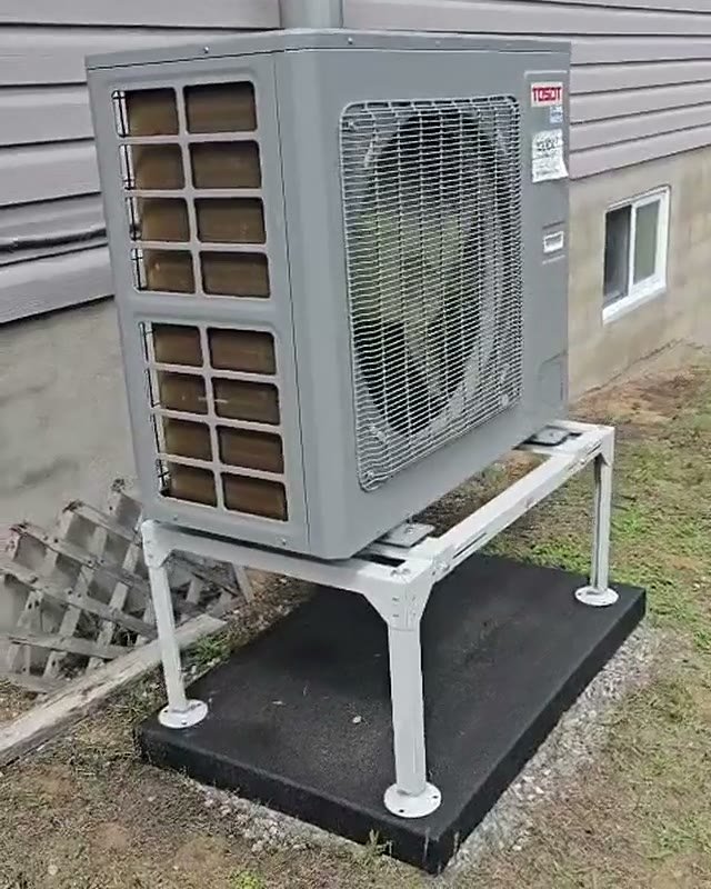 A completed HEC Ottawa heat pump installation on a levelled stand beside an Ottawa home